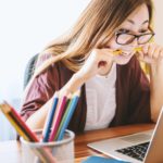 college student biting a pencil while writing