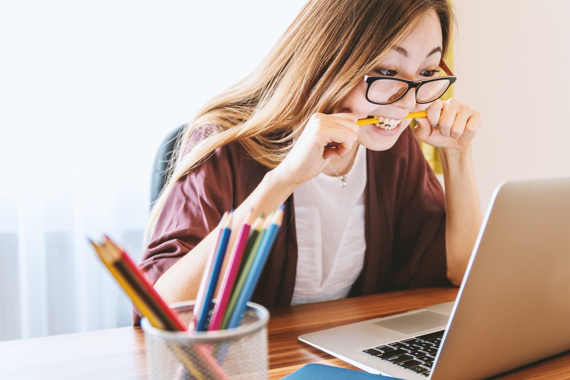 college student biting a pencil while writing